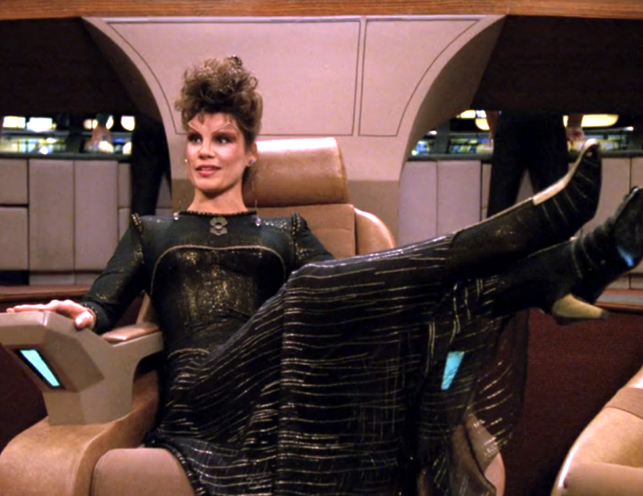 A woman claiming to be Ardra, lounging with her feet up in the Captain's chair