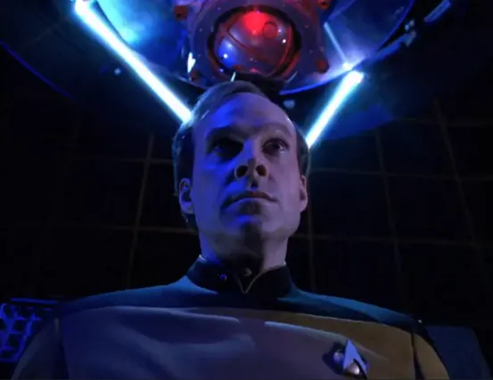 Barclay, in the holodeck, with an impressive array of instrumentation and gadgets, including several laser beams that seem to be reading his mind