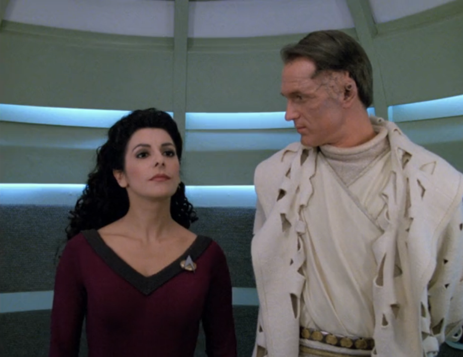 Troi and an alien man in the turbolift