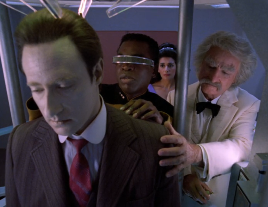 La Forge, Troi, and Sam Clemens standing around a disabled Data