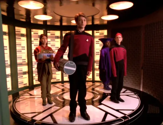 Four children on the transporter pad who look suspiciously like Picard, Keiko, Ro, and Guinan
