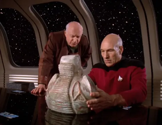 Picard and his former archeology teacher examining a porcelain artifact