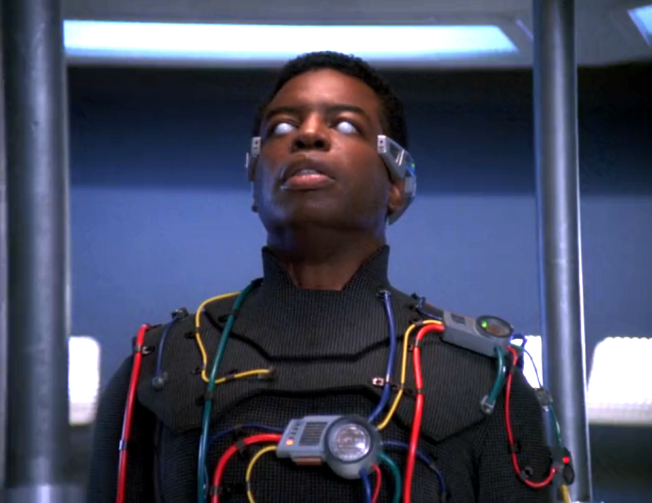 La Forge, without his VISOR, wearing a suit with wires and electronics all over it