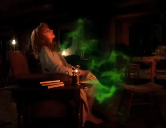 Dr. Crusher reclining in a chair as a glowing green mist envelops her