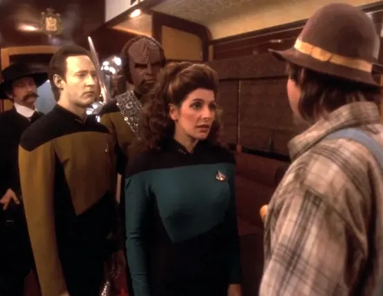 Troi, Worf, and Data talking to a passenger on the Orient Express