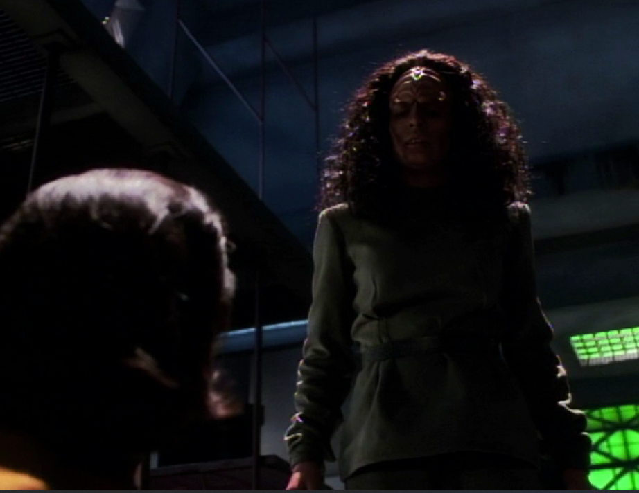 A fully-Klingon version of B'Elanna standing in a darkened room