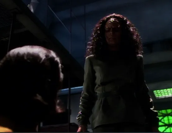 A fully-Klingon version of B'Elanna standing in a darkened room