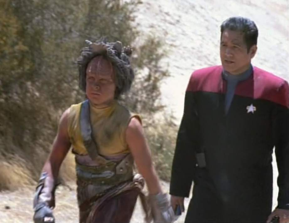 Chakotay follows a young Kazon man on a rocky planet surface