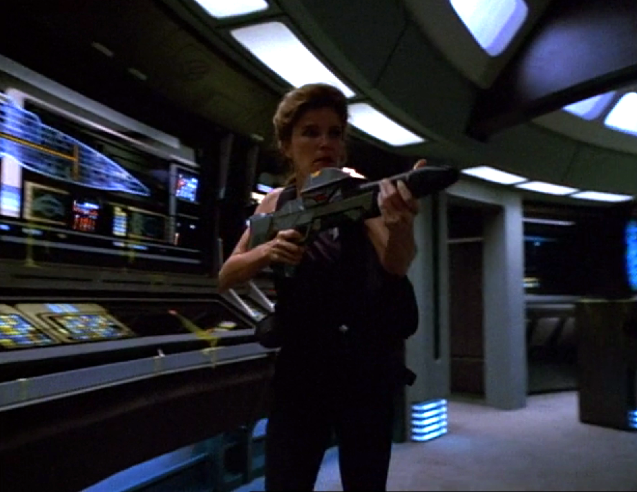 Janeway carrying a phaser rifle through Voyager's bridge