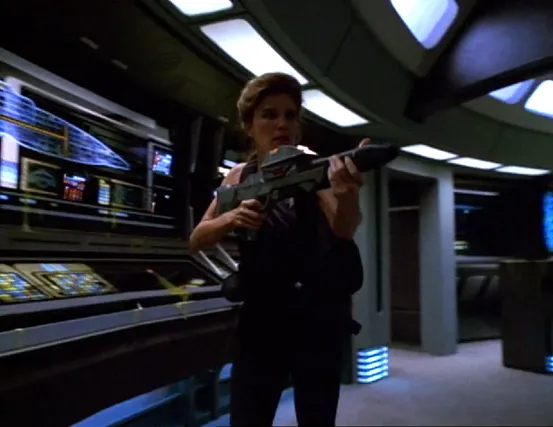 Janeway carrying a phaser rifle through Voyager's bridge