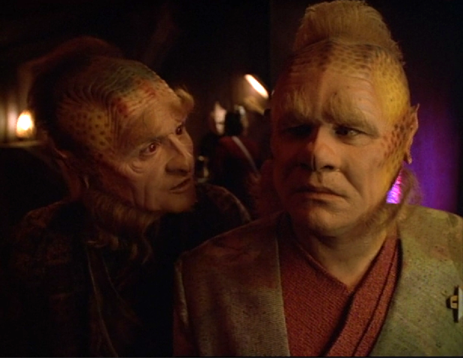 Neelix looking concerned as another Talaxian talks to him