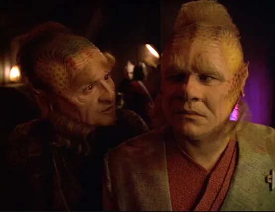 Neelix looking concerned as another Talaxian talks to him