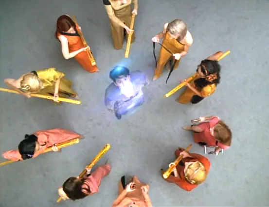 Kim being beamed up after being surrounded by ten women with staffs