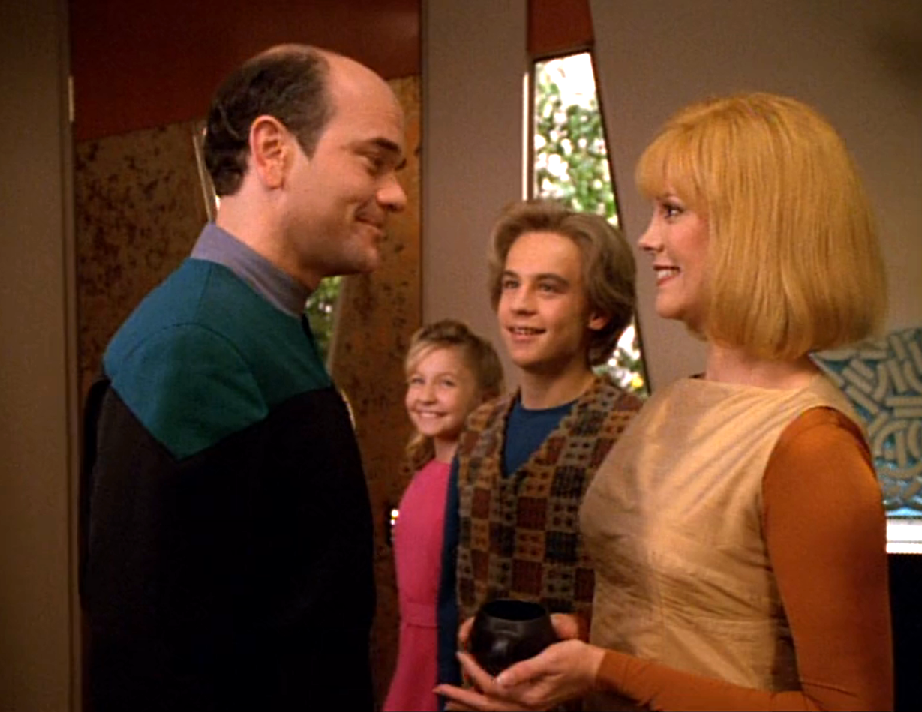 The Doctor, a woman, and two children all smiling happily