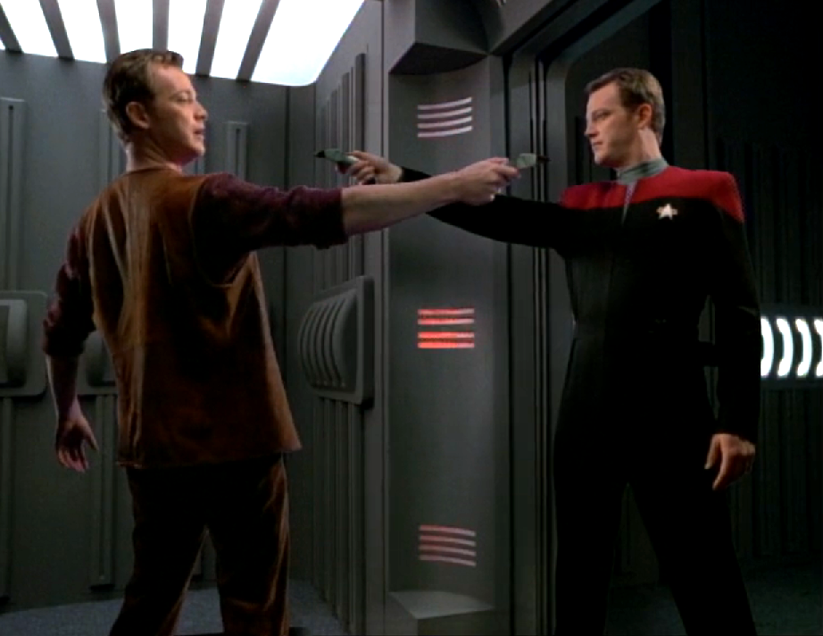 A uniformed Tom Paris and a second Paris in plain clothes pointing phasers at each other