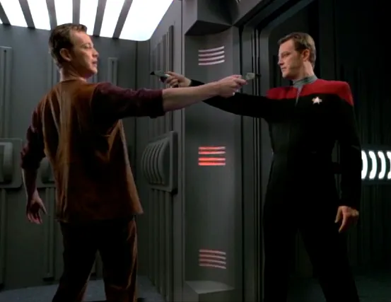 A uniformed Tom Paris and a second Paris in plain clothes pointing phasers at each other