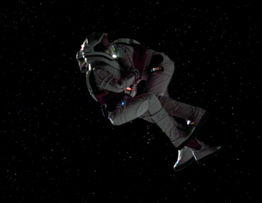 Two people in space suits, huddled together and floating in space