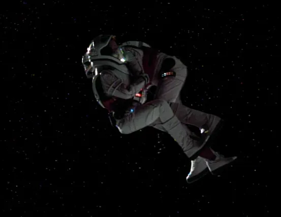 Two people in space suits, huddled together and floating in space