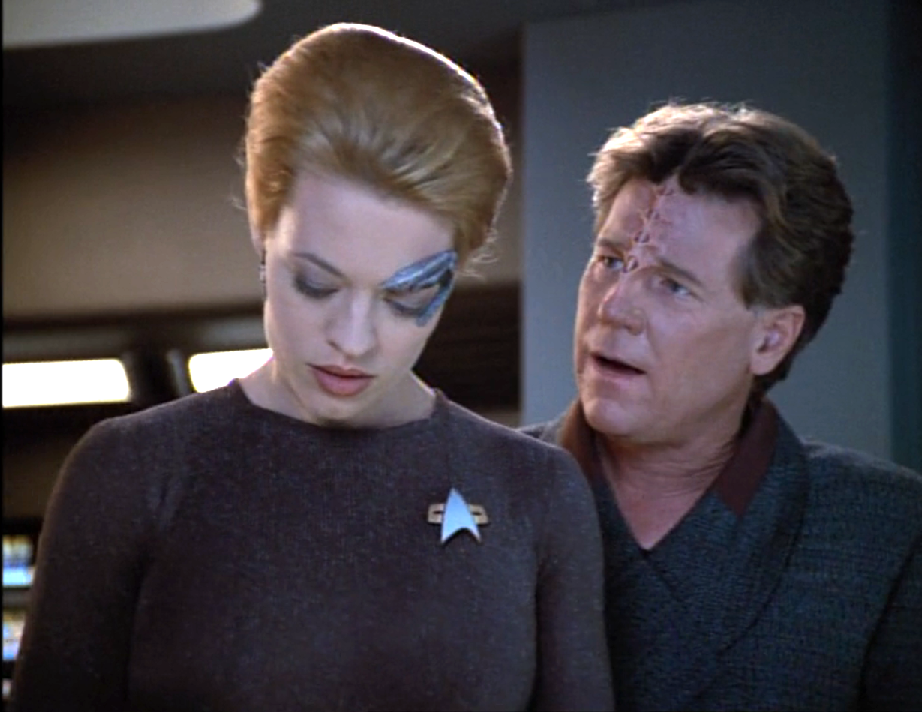 Seven of Nine looking annoyed at the presence of an alien man