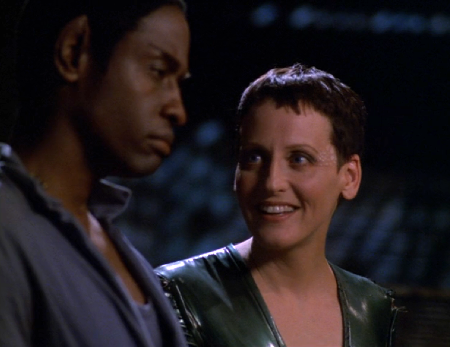 An alien woman named Noss smiling as she has a conversation with Tuvok
