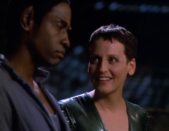 An alien woman named Noss smiling as she has a conversation with Tuvok