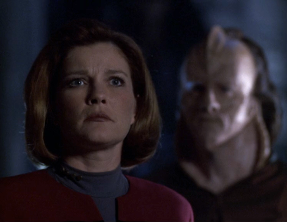 Captain Janeway and one of the Vaadwaur, who has a flared, cobra-like neck