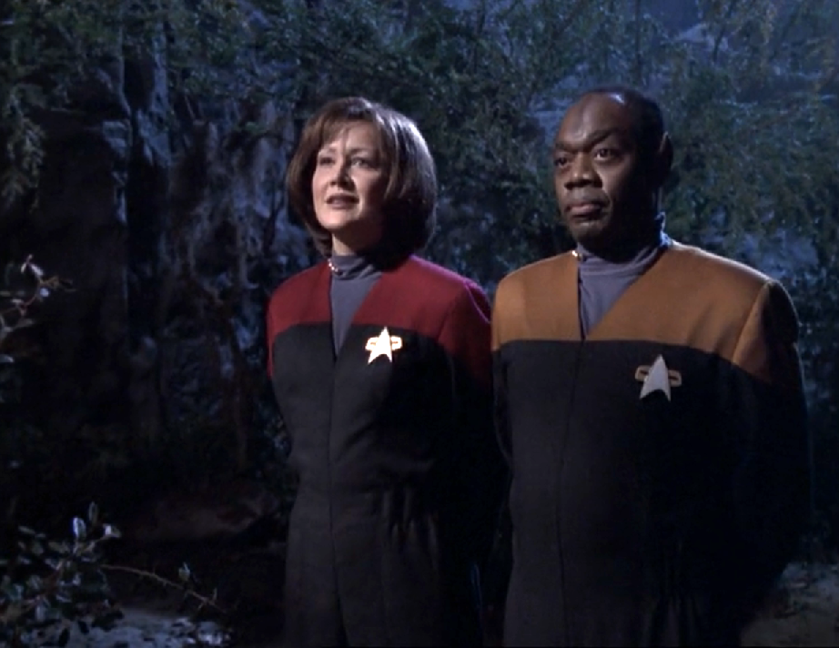 Two impostors impersonating Janeway and Tuvok, wearing ill-fitting uniforms and comically-large combadges