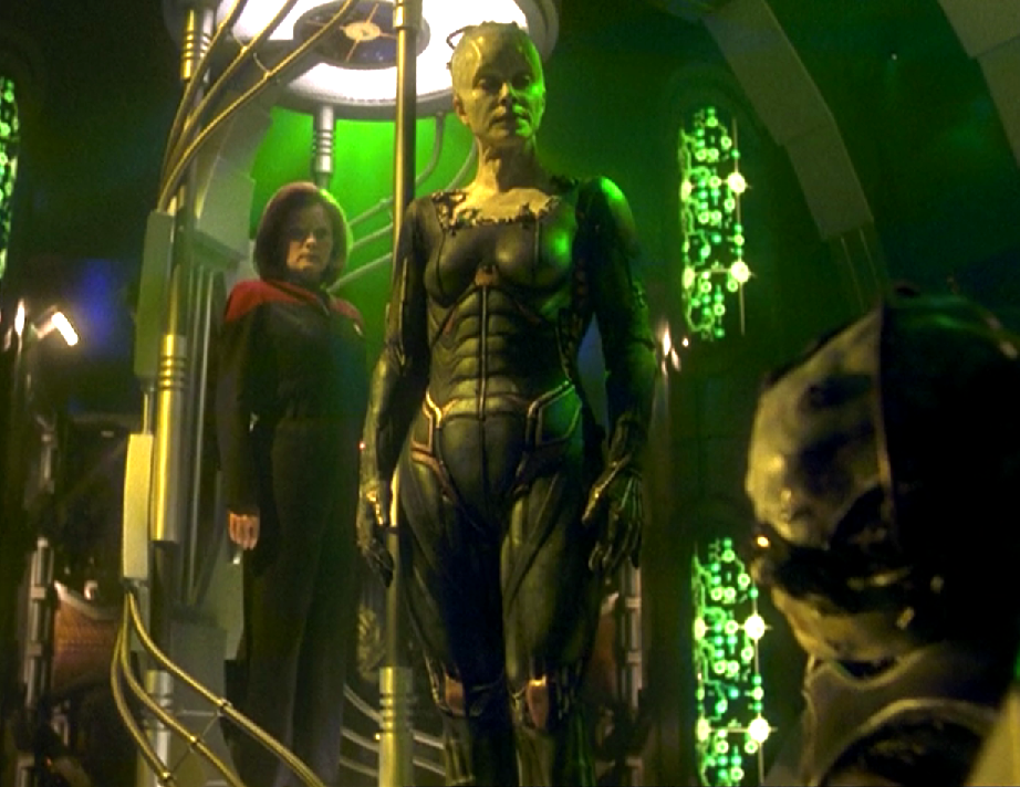 Janeway and the Borg Queen standing over a dead Borg drone
