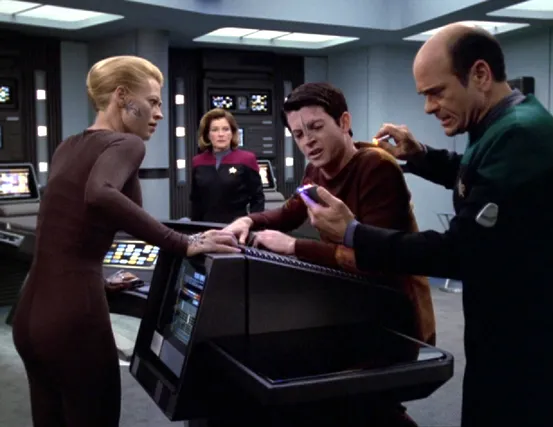 Seven, Janeway, Icheb, and the Doctor in sickbay. Seven and Icheb both appear impaired as the Doctor scans them