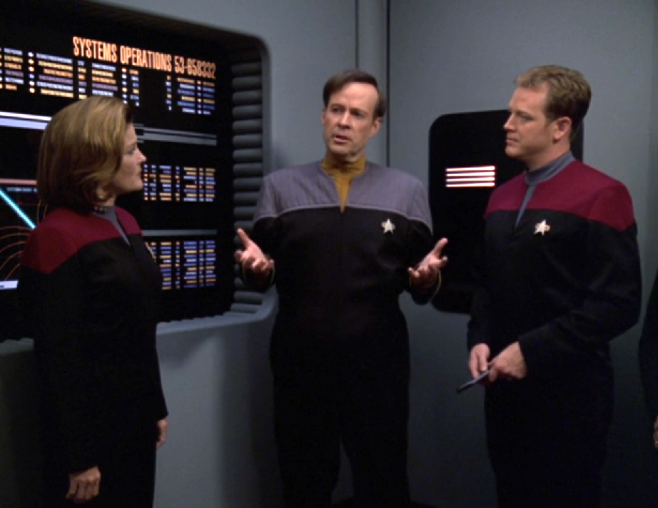 Reginald Barclay speaking to the Voyager crew in the conference room