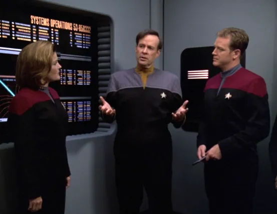 Reginald Barclay speaking to the Voyager crew in the conference room