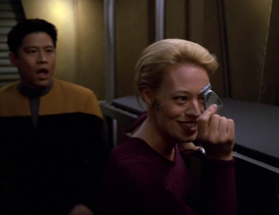 Harry Kim looking shocked as Seven of Nine appears very happy to be holding the Doctor's mobile emitter