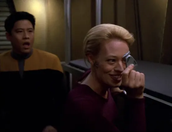 Harry Kim looking shocked as Seven of Nine appears very happy to be holding the Doctor's mobile emitter
