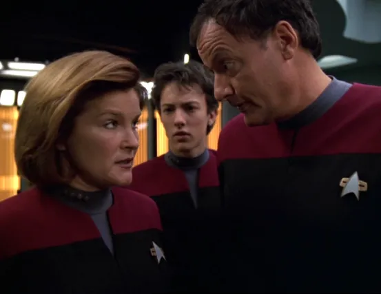 Janeway and Q have a conversation while Q's son watches, concerned